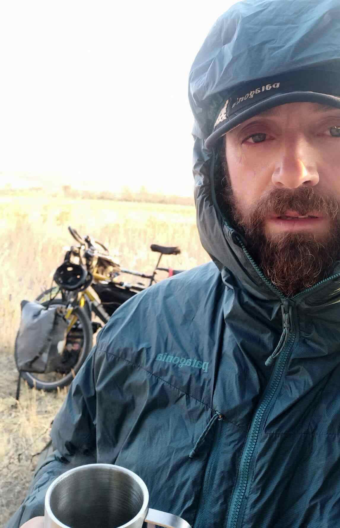 homme devant son vélo de voyage