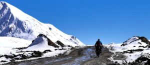 voyage a velo sur mesure cyclovoyageur sur une route en montagne